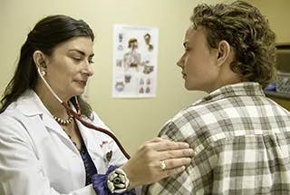 doctor uses stethoscope on patient 