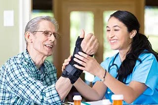 Medical professional helps patient with wrist brace.