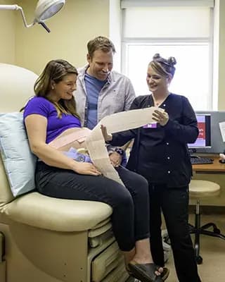 Ultrasound technician shows smiling couple scans