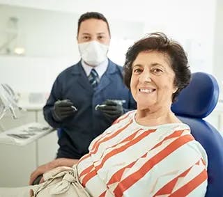 Dentist and patient smile at camera