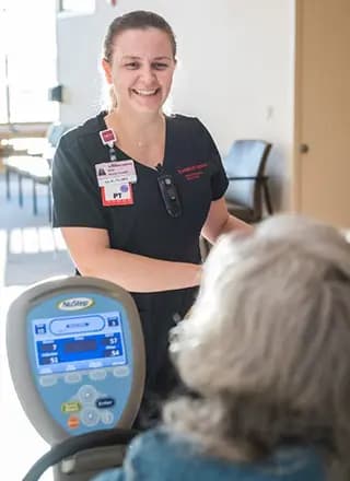 Medical professional smiles down at a patient.