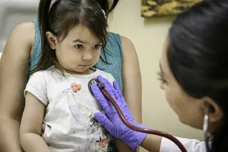 Doctor using stethoscope on a child